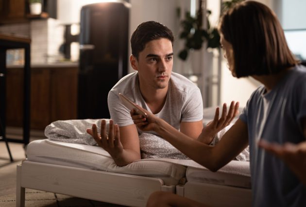 young man having conflict with his girlfriend who caught him cheating her phone